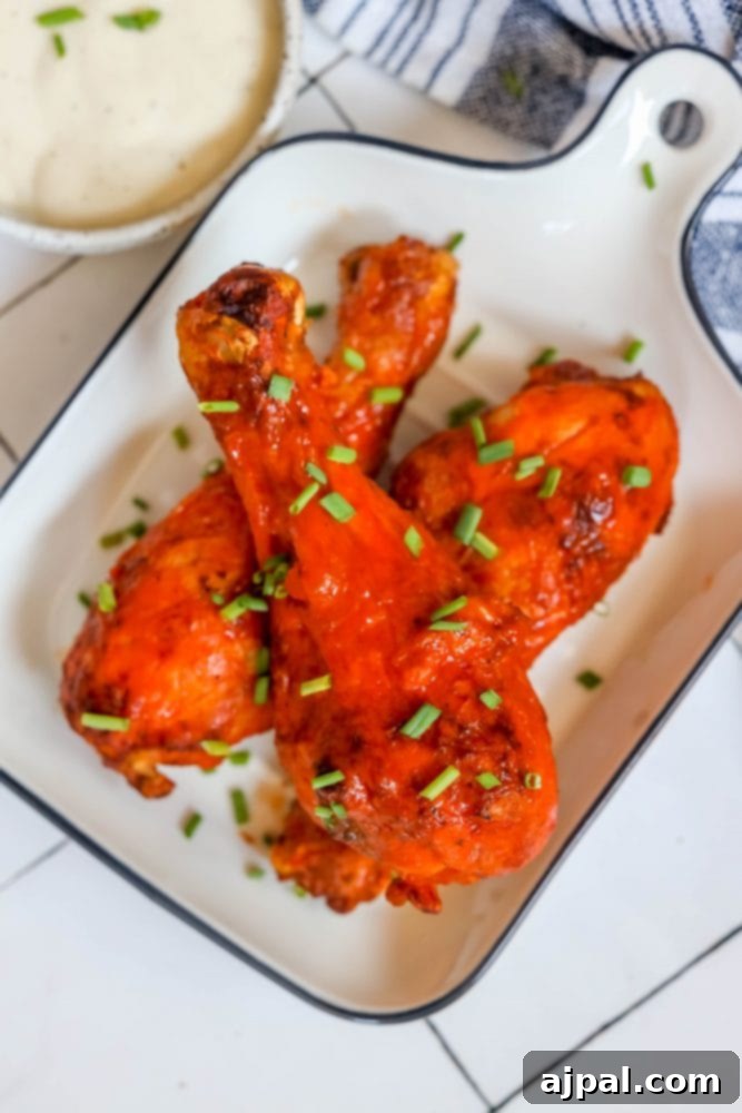 Ultimate Crispy Buffalo Drumsticks 3 Platter of crunchy buffalo chicken legs with a vibrant red sauce, perfectly tangy and spicy.