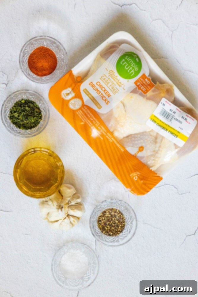 Ultimate Crispy Buffalo Drumsticks 4 Raw chicken legs, a bottle of olive oil, and various spices arranged on a rustic wooden table.