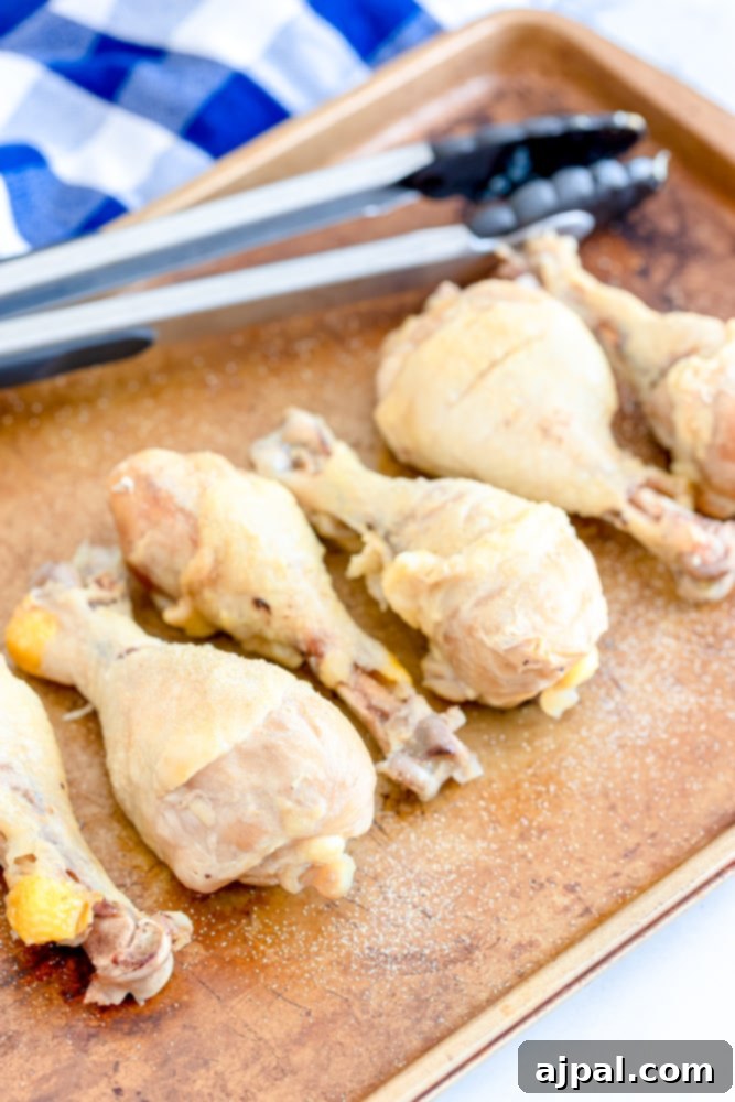 Ultimate Crispy Buffalo Drumsticks 5 Seasoned chicken legs neatly arranged on a baking sheet, ready for the oven.