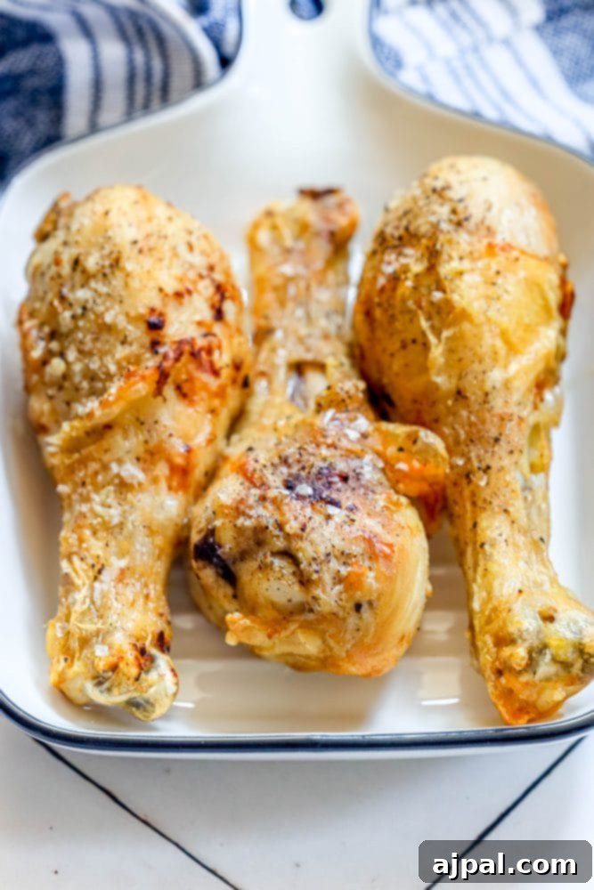 Ultimate Crispy Buffalo Drumsticks 6 Three perfectly crispy, golden-brown chicken drumsticks on a plate with a classic blue and white checkered tablecloth.