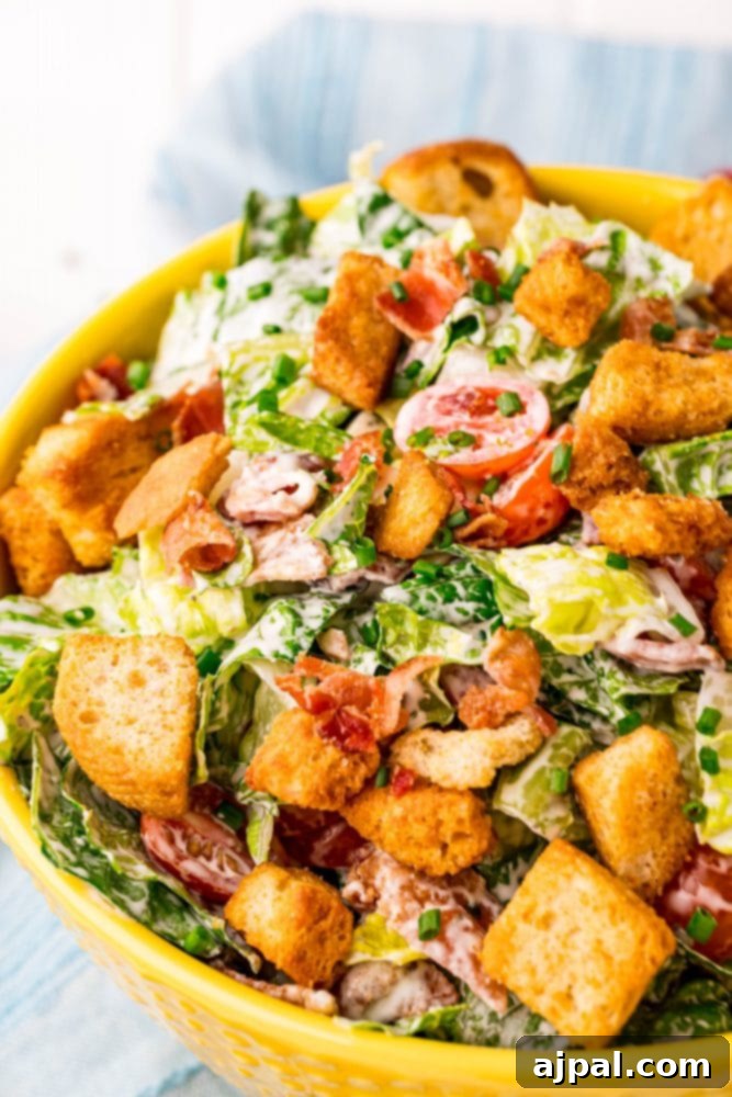 Effortless BLT Salad 4 Caesar salad with croutons served in a yellow bowl.