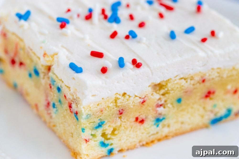 Stars and Stripes Sugar Cookie Bars 6 A slice of festive 4th of July funfetti sugar cookie bar, showcasing its vibrant red, white, and blue sprinkles embedded in a vanilla cake.