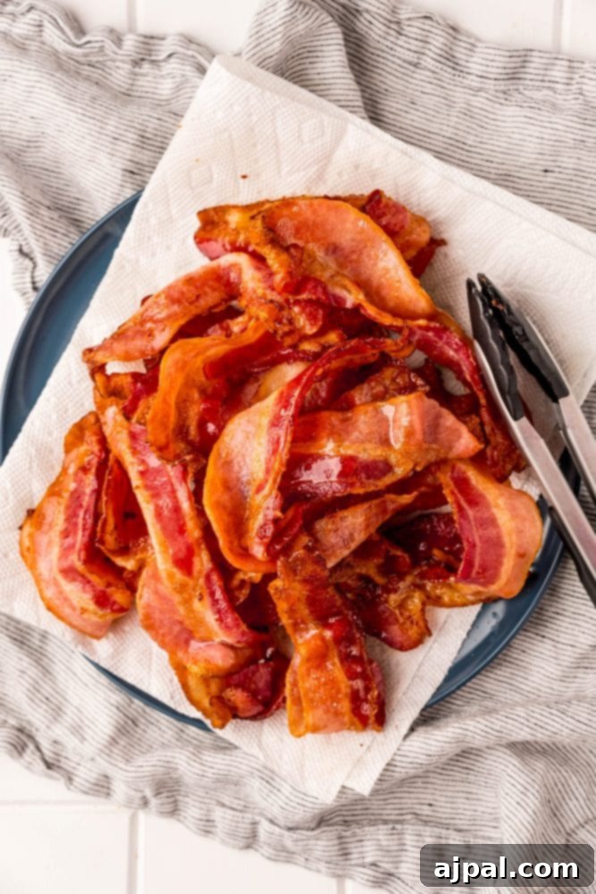 Crispy air-fried bacon resting on a plate lined with paper towels, ready to be enjoyed.
