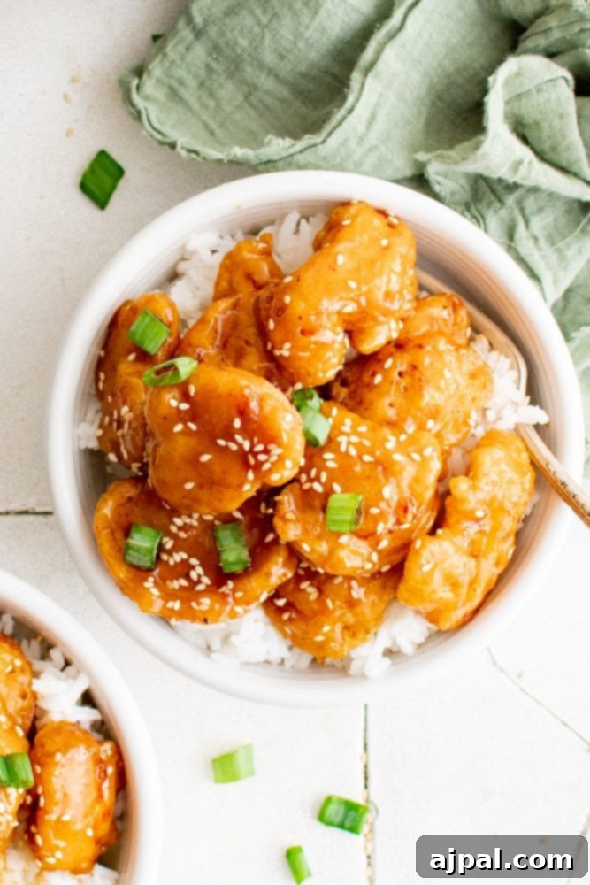 Effortless Sesame Chicken 3 picture of sesame chicken in a bowl over rice, ready to be served