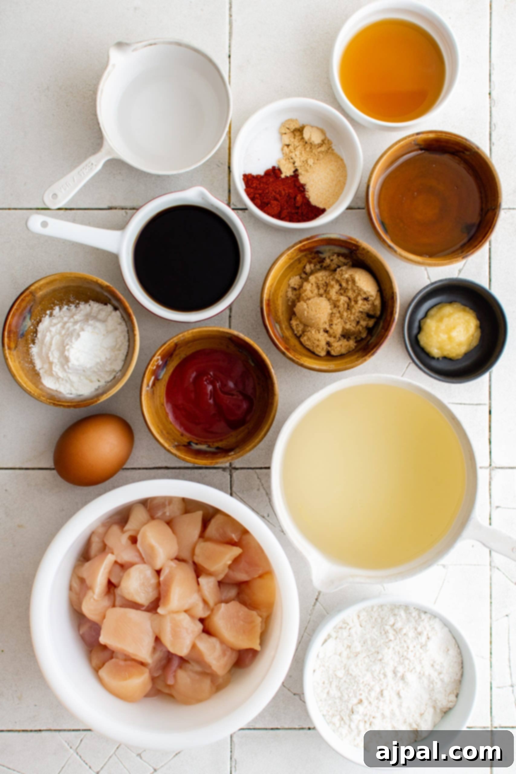 Effortless Sesame Chicken 5 An assortment of ingredients for easy sesame chicken in bowls, laid out on a kitchen surface