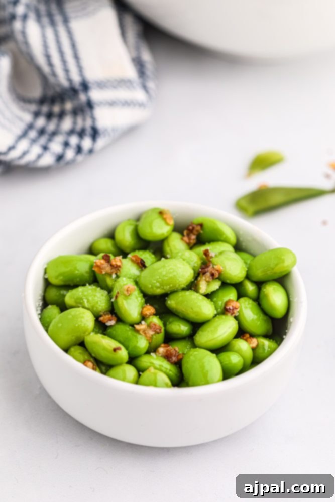 A delightful serving of green edamame beans in a white bowl, ready to be enjoyed.