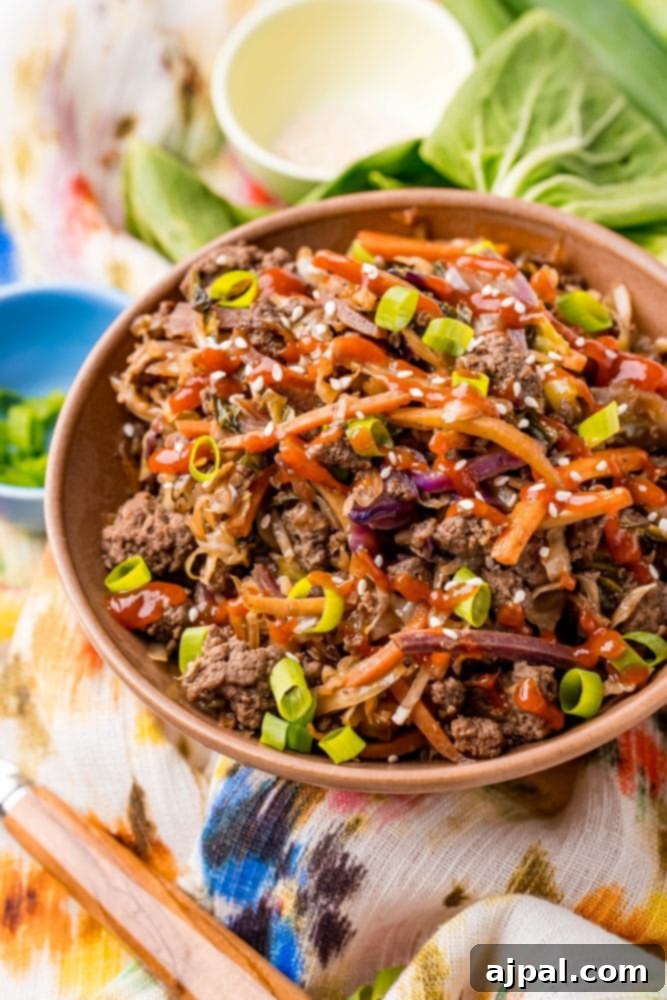 A vibrant bowl of Keto Egg Roll in a Bowl with ground meat and crisp bok choy in the background, signaling a healthy and delicious meal.