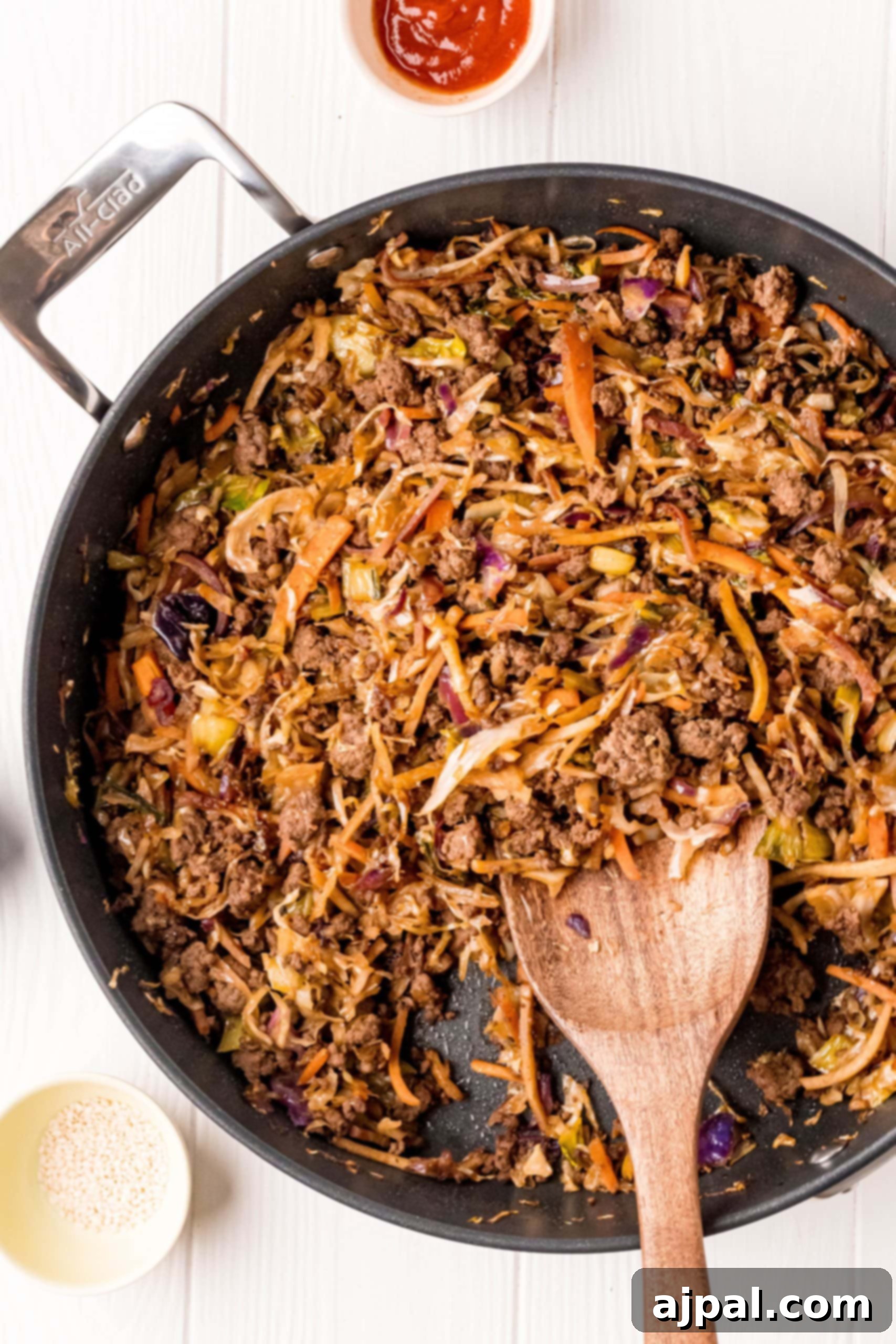 A nutritious skillet full of fried rice with meat and vegetables, perfect for a quick and delicious egg roll in a bowl recipe.