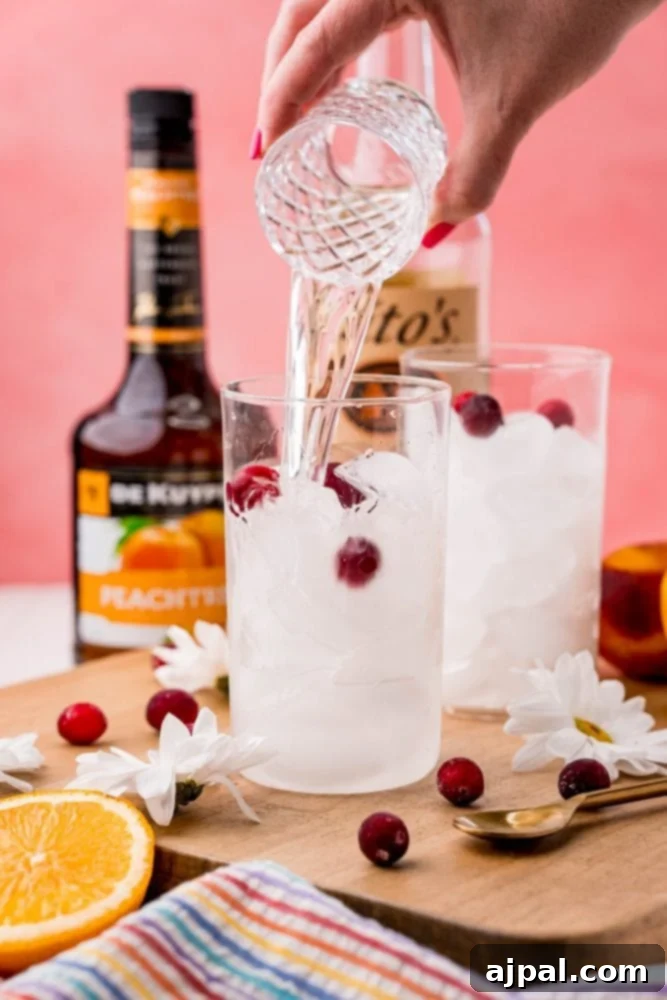 The Ultimate Sex on the Beach Cocktail Guide 6 Peach schnapps being poured into a cocktail glass filled with ice, as part of the Sex on the Beach recipe.