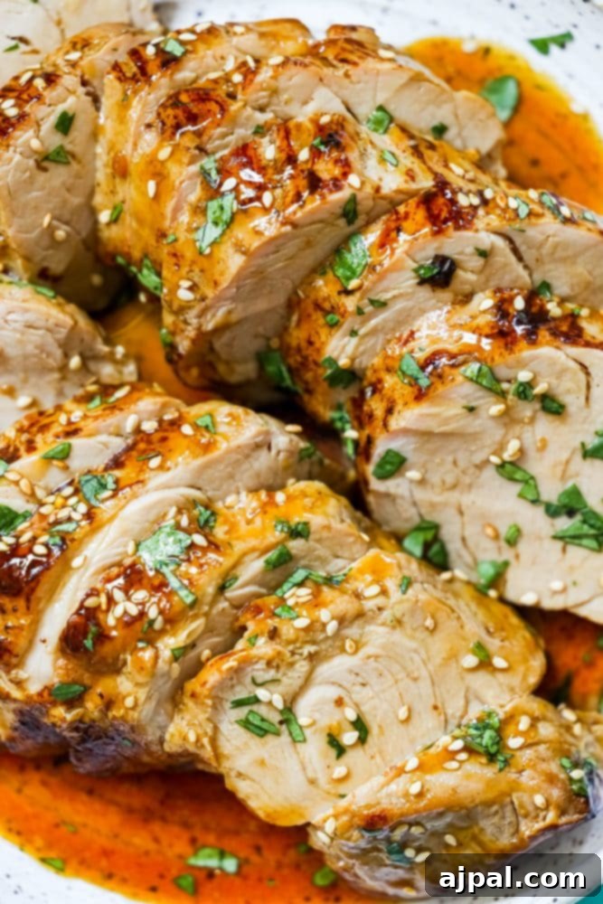 Best Baked Teriyaki Pork Tenderloin 2 sliced pork tenderloin in teriyaki sauce with sesame seeds on top