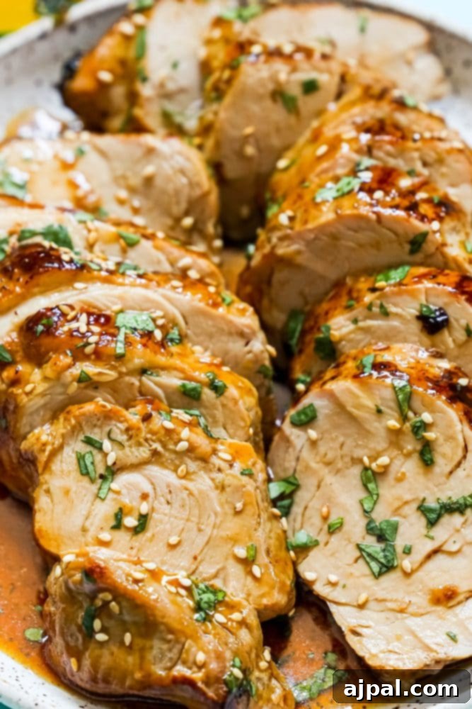 Best Baked Teriyaki Pork Tenderloin 11 sliced pork tenderloin in teriyaki sauce with sesame seeds on top