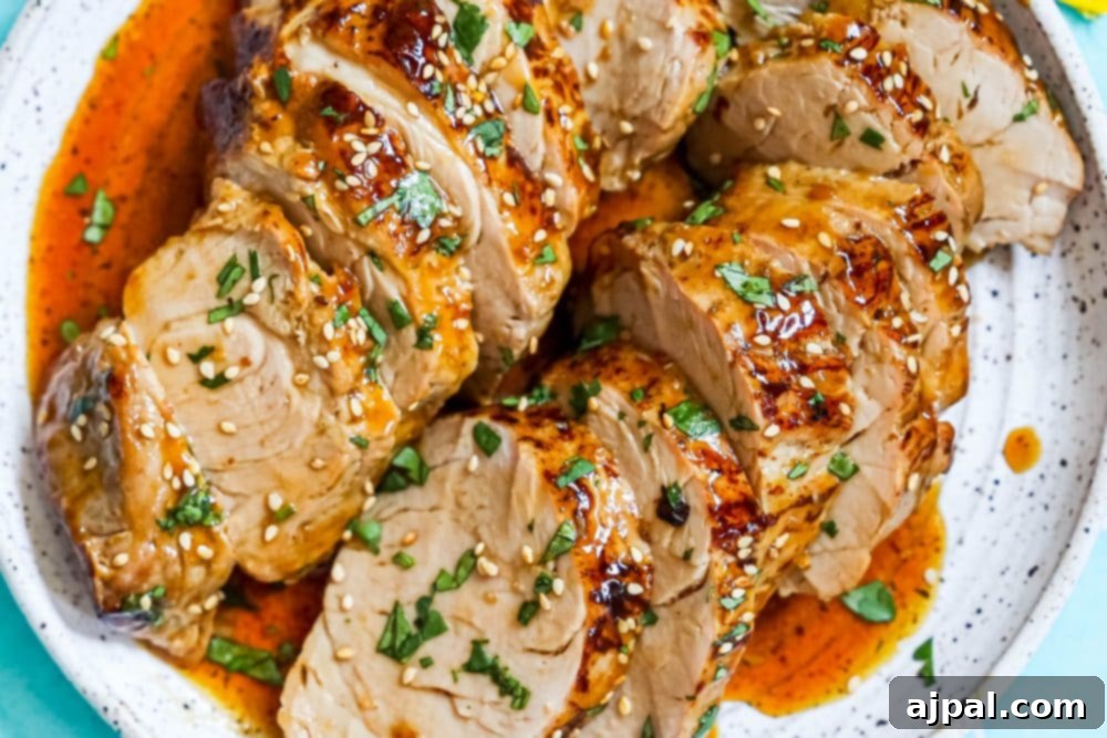 Best Baked Teriyaki Pork Tenderloin 12 sliced pork tenderloin in teriyaki sauce with sesame seeds on top
