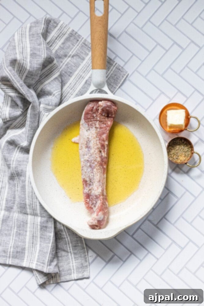 Best Baked Teriyaki Pork Tenderloin 7 picture of pan with olive oil and raw pork tenderloin in it
