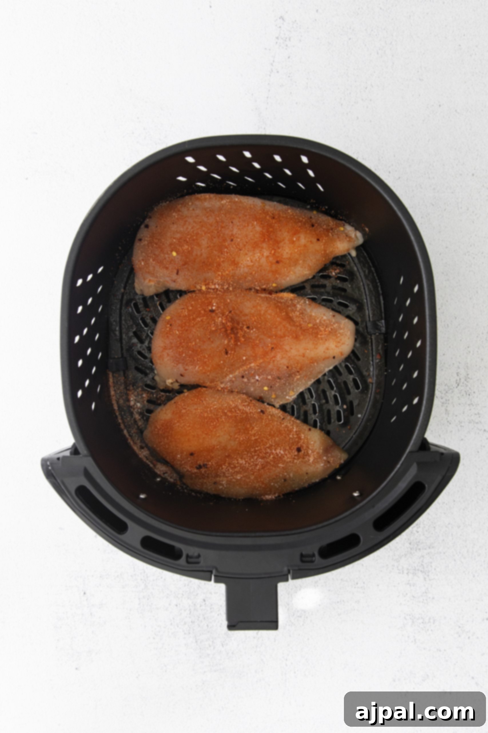 Tender Air Fryer BBQ Chicken Breasts 7 Air-fried BBQ chicken breasts cooked in an air fryer, presented on a white background.