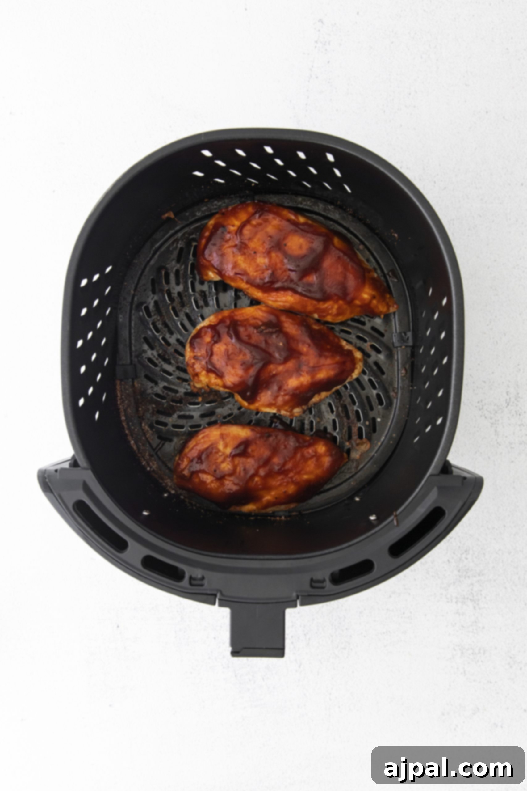 Tender Air Fryer BBQ Chicken Breasts 9 Air fryer BBQ chicken on a white background.