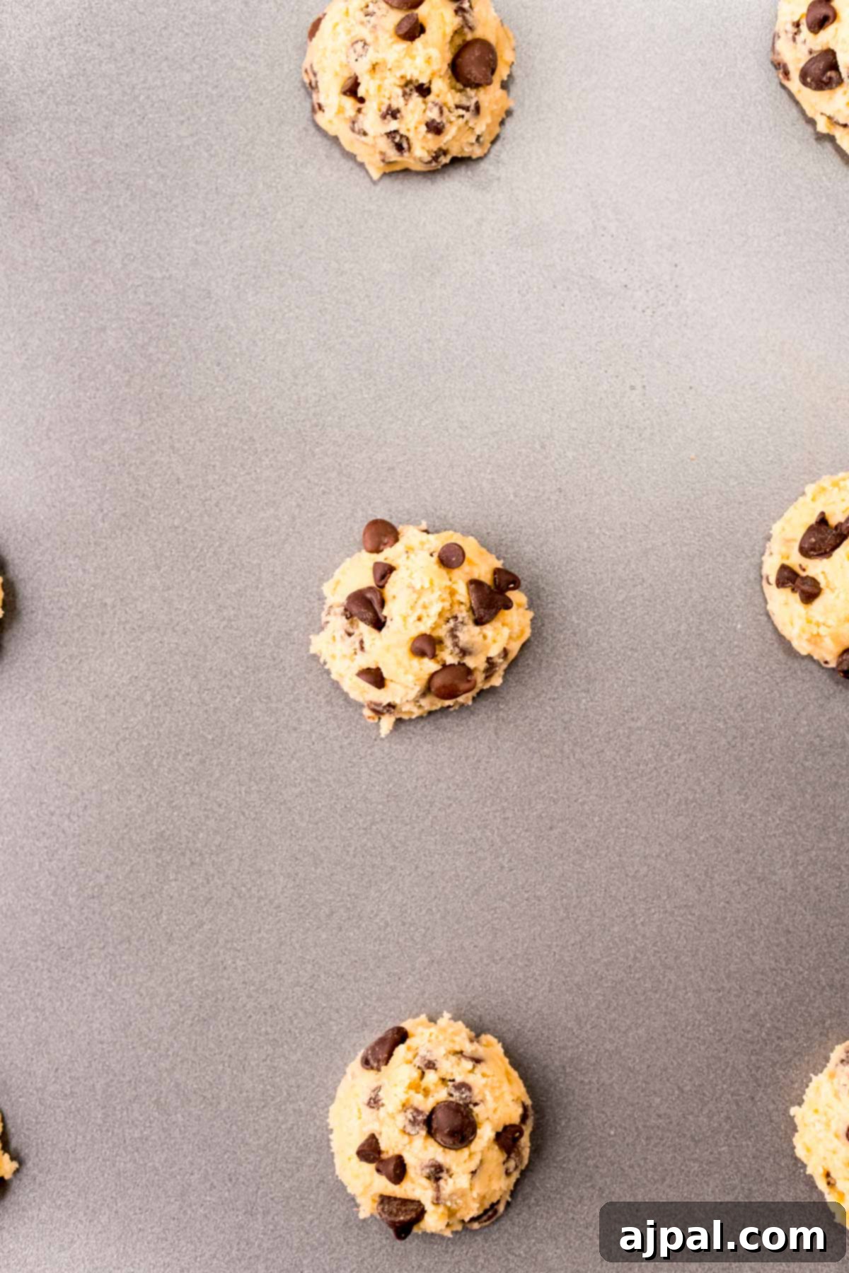 Ultimate Chewy Chocolate Chip Cookies 6 A freshly baked batch of chewy chocolate chip cookies, golden-brown and still warm, arranged on a baking sheet.