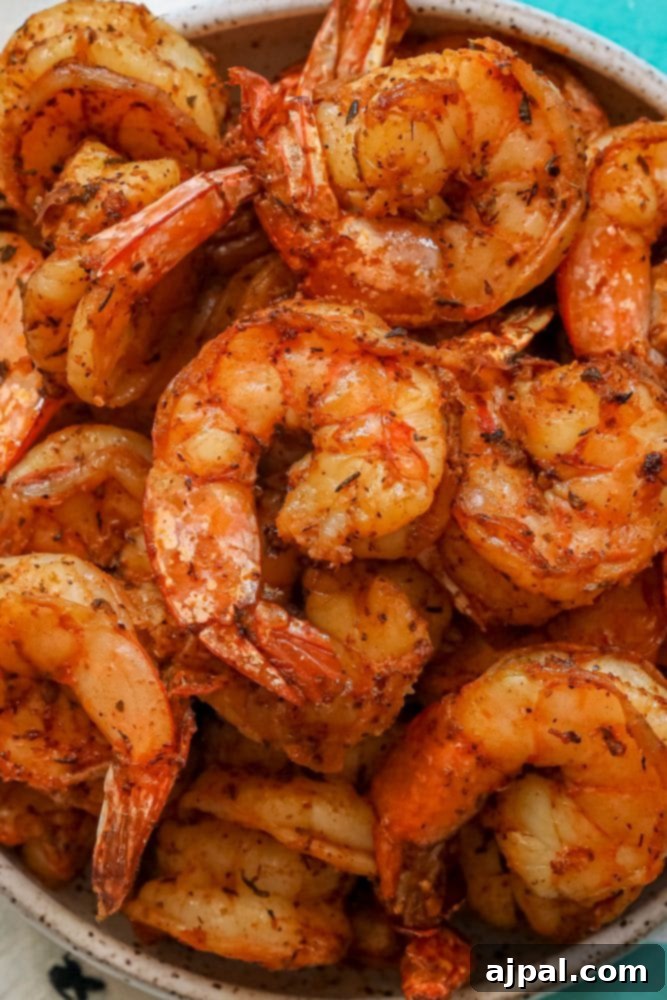 Perfectly Blackened Air Fryer Shrimp 6 Grilled shrimp in a bowl on a table.