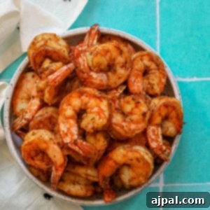 Perfectly Blackened Air Fryer Shrimp 9 Grilled blackened shrimp in a bowl on a blue tile.