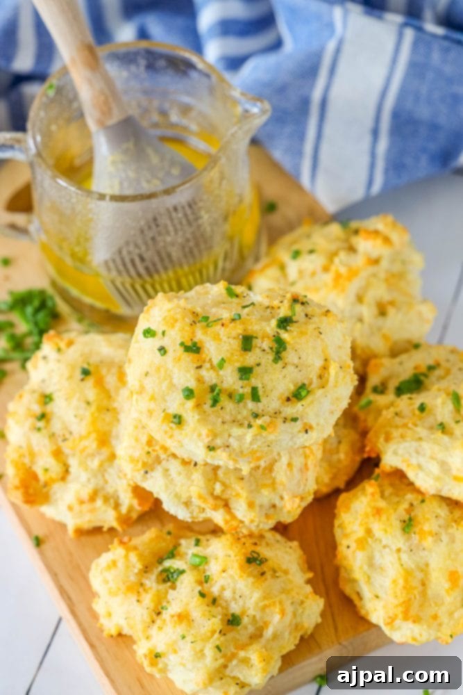 Whip Up Irresistible Cheesy Garlic Biscuits 2 cheddar bay biscuits piled on top of each other on a cutting board