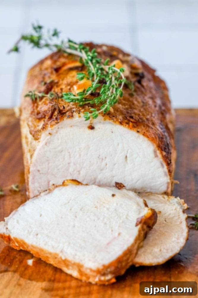 pork loin on a cutting board with shallots, and rosemary