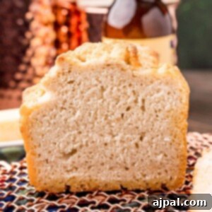 beer bread on a cooling rack in front of a bottle of beer