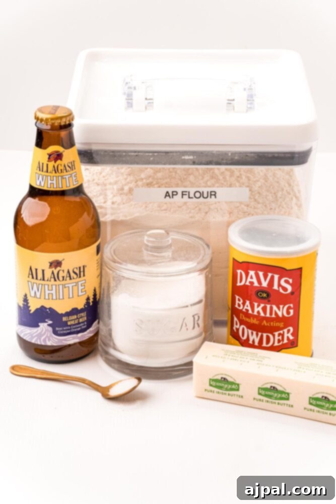 Various ingredients for beer bread, including beer, flour, baking powder, sugar, and butter, neatly arranged on a rustic table.