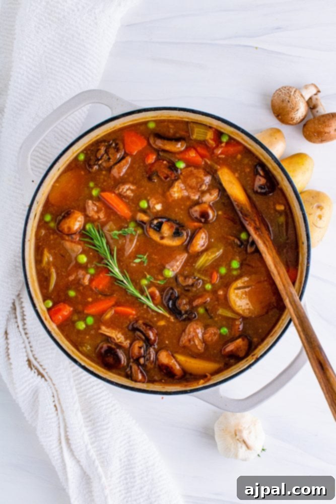 A Dutch oven filled with a rich venison stew, featuring tender meat, vegetables, and a deep, inviting color.