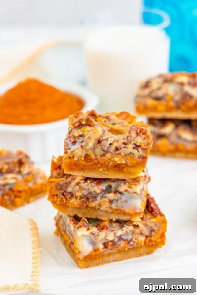 Stacked pumpkin pie bars with pecans and a golden cookie base on a rustic table setting