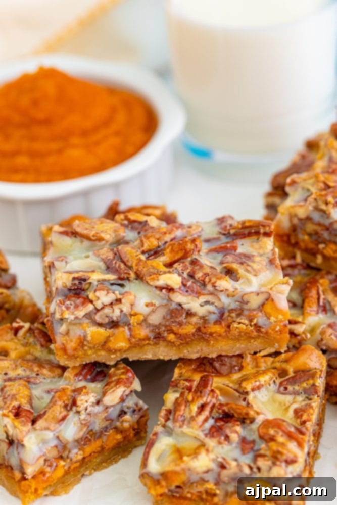A delicious stack of pumpkin magic bars on a plate next to a refreshing glass of milk
