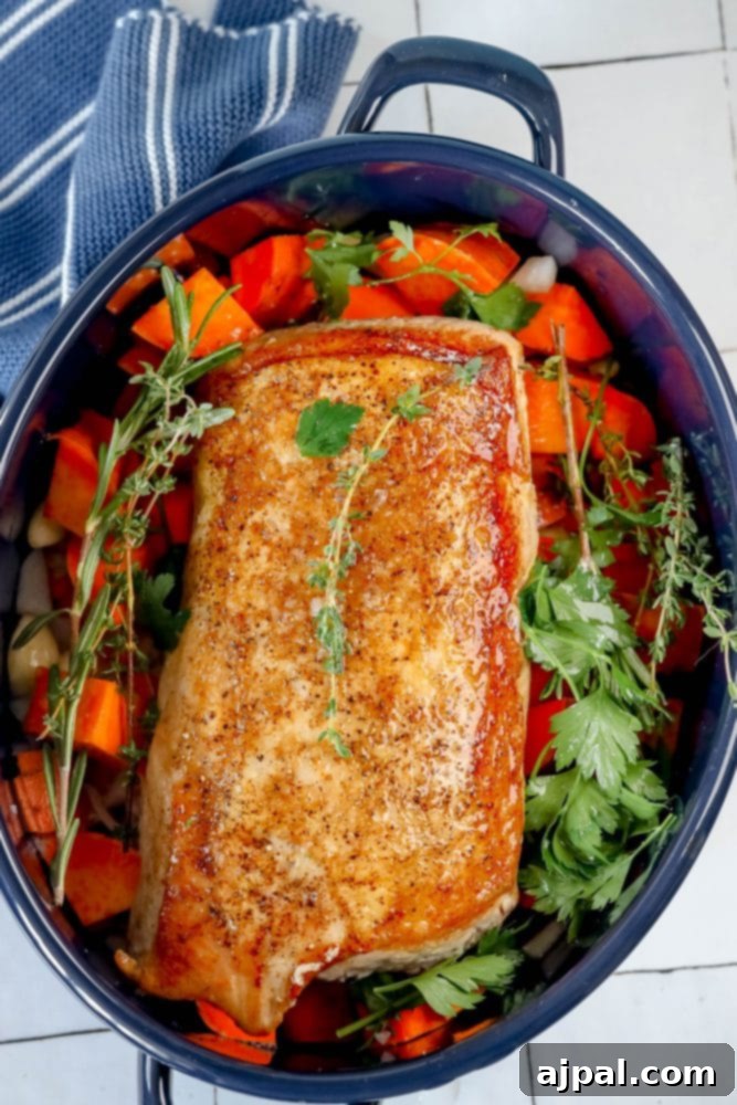 The roasted pork loin and sweet potatoes, golden and tender, fresh out of the oven in the roasting pan.