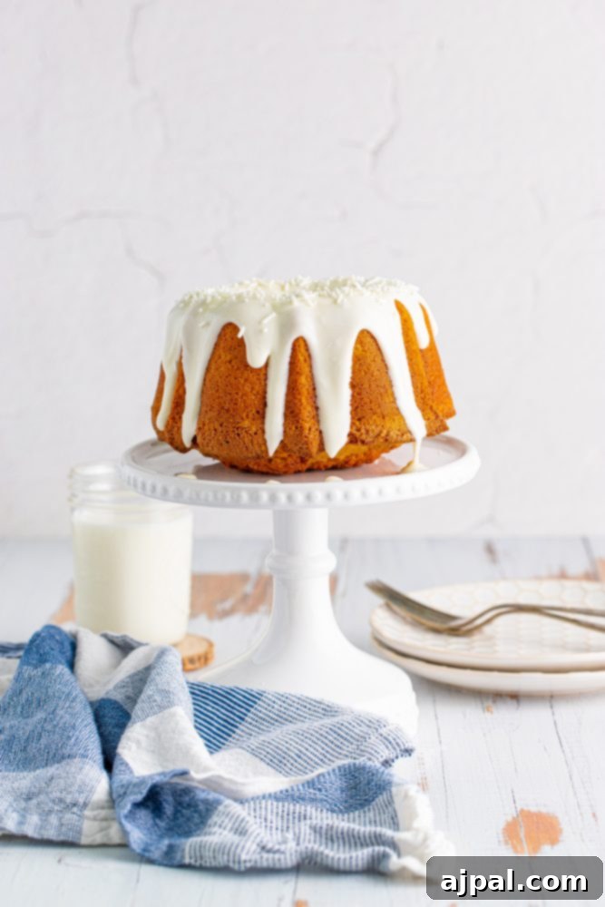 Perfect Air Fryer Pumpkin Bundt Cake 2 A beautifully glazed air fryer pumpkin bundt cake on a pristine white cake stand, ready to be served.