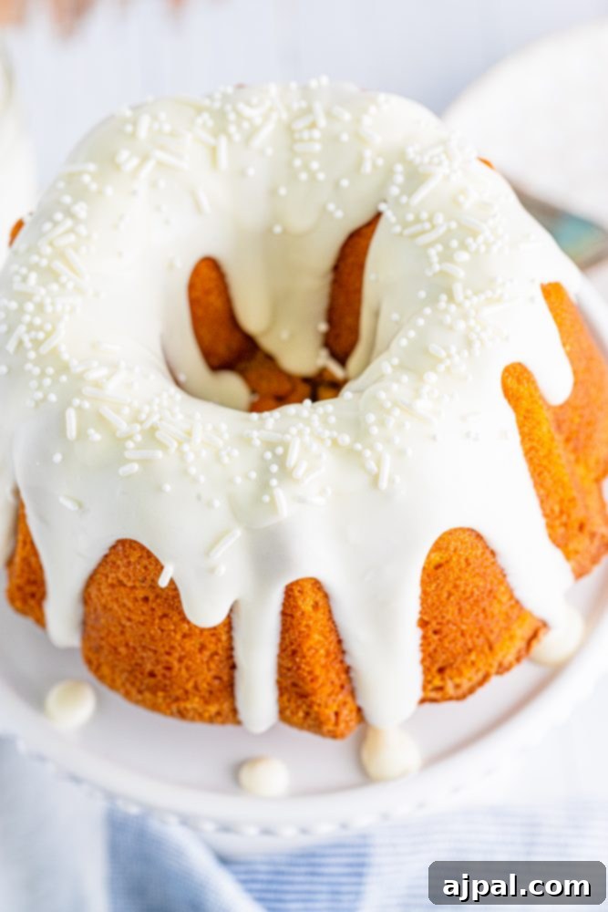 Perfect Air Fryer Pumpkin Bundt Cake 14 A delightful air fryer pumpkin bundt cake, lavishly coated with a rich cream cheese glaze, resting on a crisp white plate.