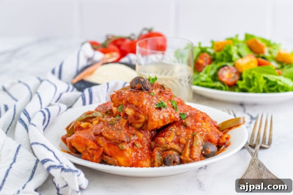 Simple Steps to Perfect Chicken Cacciatore 15 A beautifully plated dish of Chicken Cacciatore in tomato sauce, accompanied by a fresh side salad.