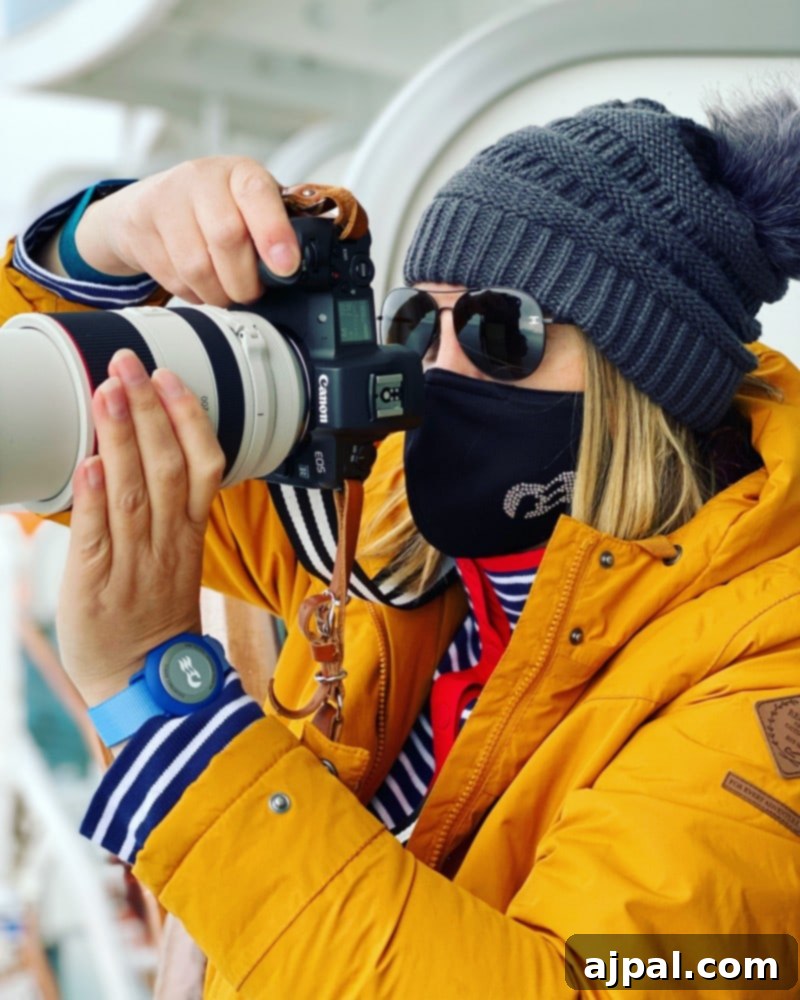 Post-Pandemic Cruising: What to Really Expect 2 picture of woman in yellow jacket holding a camera with a princess cruises face mask
