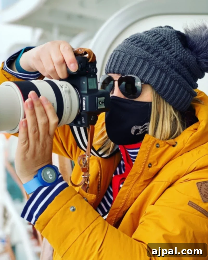 Cruising Post-Pandemic: A Reality Check 2 picture of woman in yellow jacket holding a camera with a princess cruises face mask