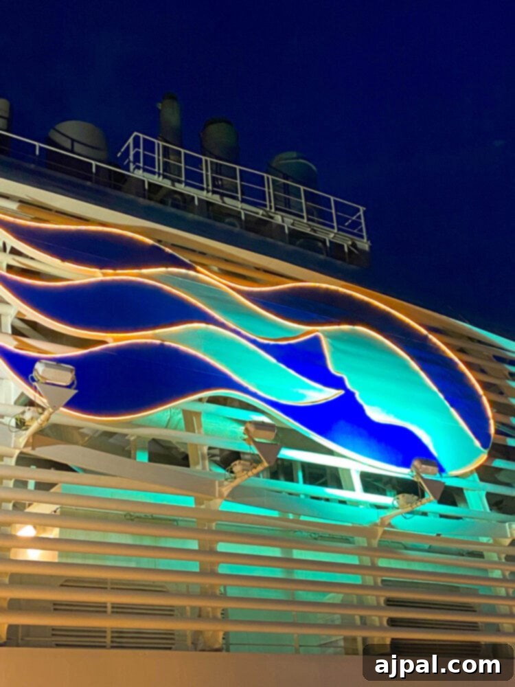 Cruising Post-Pandemic: A Reality Check 13 picture of the Princess Cruises logo lit up on the side of the Majestic Princess ship at night