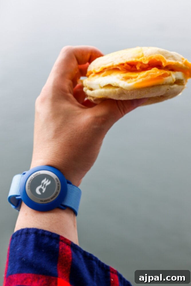 Post-Pandemic Cruising: What to Really Expect 23 picture of hand holding egg muffin on princess cruise ship with medallion bracelet