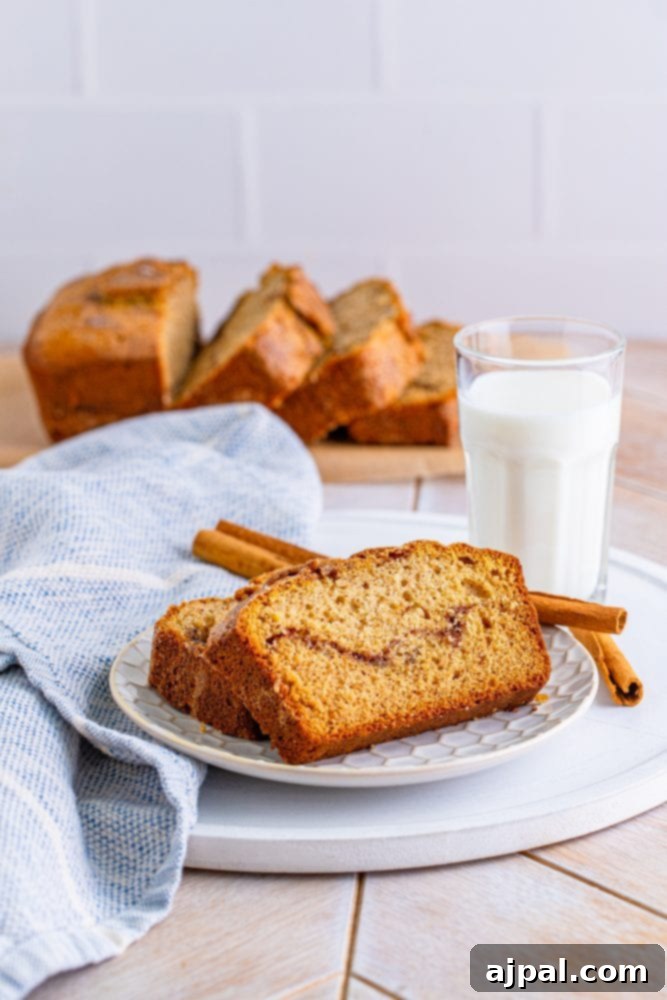 A plate with a slice of cinnamon quick bread and a glass of milk.