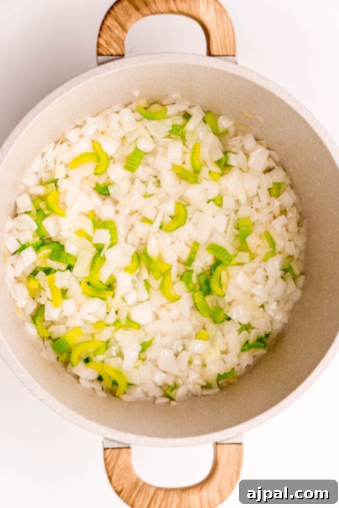 Creamy Corn Chowder 6 A pot filled with sauteed onions and green peppers, forming the base for a savory corn chowder.