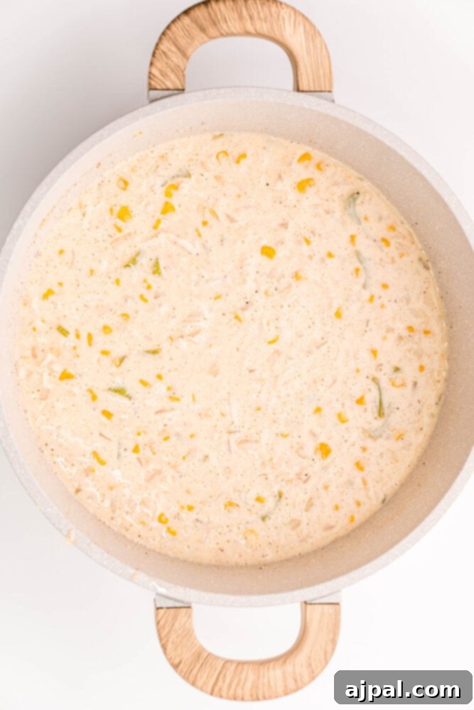 Creamy Corn Chowder 9 A pot containing the beginnings of a chicken and corn chowder, with a separate bowl of shredded chicken ready to be added.