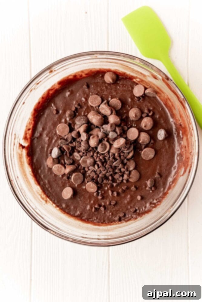 No-Bake Brownie Batter 6 Ingredients for edible brownie batter, including melted butter and heavy cream, being added to the heat-treated brownie mix in a bowl.
