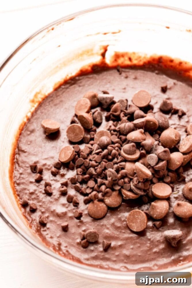 No-Bake Brownie Batter 7 A serving of rich, fudgy edible brownie batter in a bowl, generously topped with mini chocolate chips, ready for a delicious spoonful.