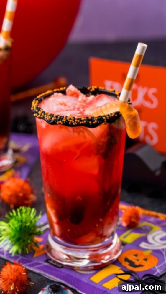 A glass filled with shimmering Halloween punch, showcasing its vibrant color and festive appearance.