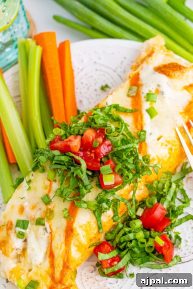 A single, perfectly served Buffalo Ranch Chicken Enchilada, ready to be savored, accompanied by a fork and fresh vegetables.