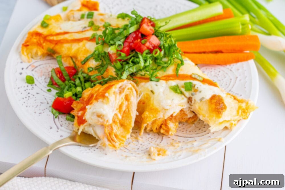 A wide shot of Buffalo Chicken Enchiladas served with fresh carrots and celery, highlighting a complete and inviting meal.