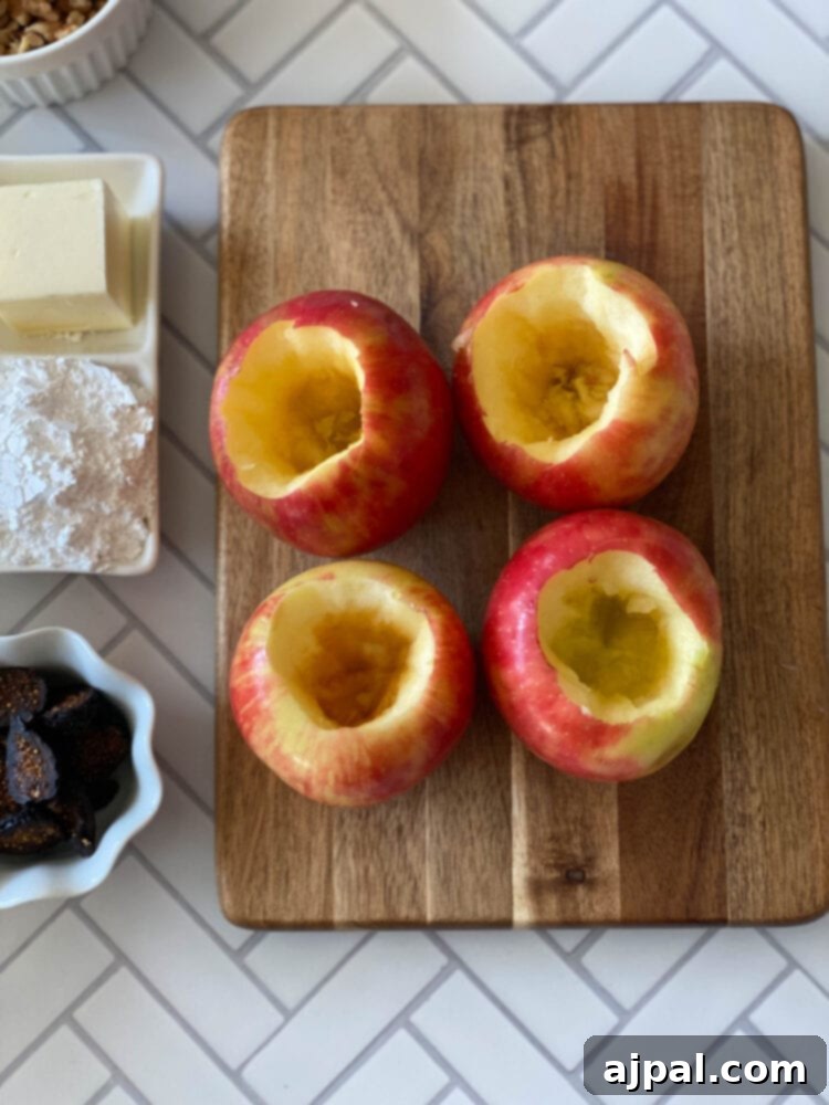 Simple Baked Apples with Figs 6 picture of cored apples with confectioners sugar, butter, cinnamon, walnuts, and figs on a table