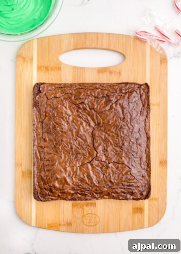 Festive Fudgy Evergreen Brownies 9 Baked brownies cooling on a cutting board after being removed from the pan, looking rich and ready for the next step.