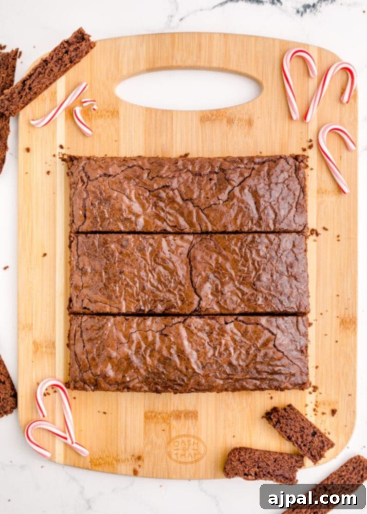Festive Fudgy Evergreen Brownies 10 Brownies carefully sliced into even rectangular strips on a cutting board, creating the base for the Christmas tree shapes.