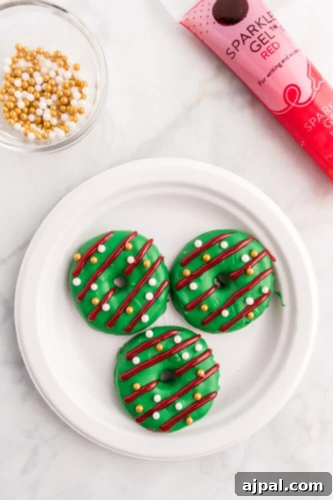Effortless Christmas Wreath Cookies 12 A charming green Christmas wreath cookie featuring a delightful licorice bow, a sprinkle of red sanding sugar, and whimsical white glitter gel dots.