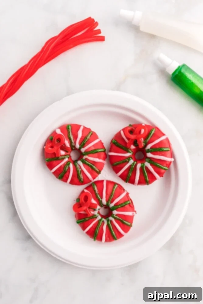 Effortless Christmas Wreath Cookies 13 A playful red Christmas wreath cookie expertly decorated with a classic Santa belt design, complete with a gleaming buckle.